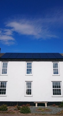 Large renovated house with sixteen solar panels producing electricity for a family living near Cambridge